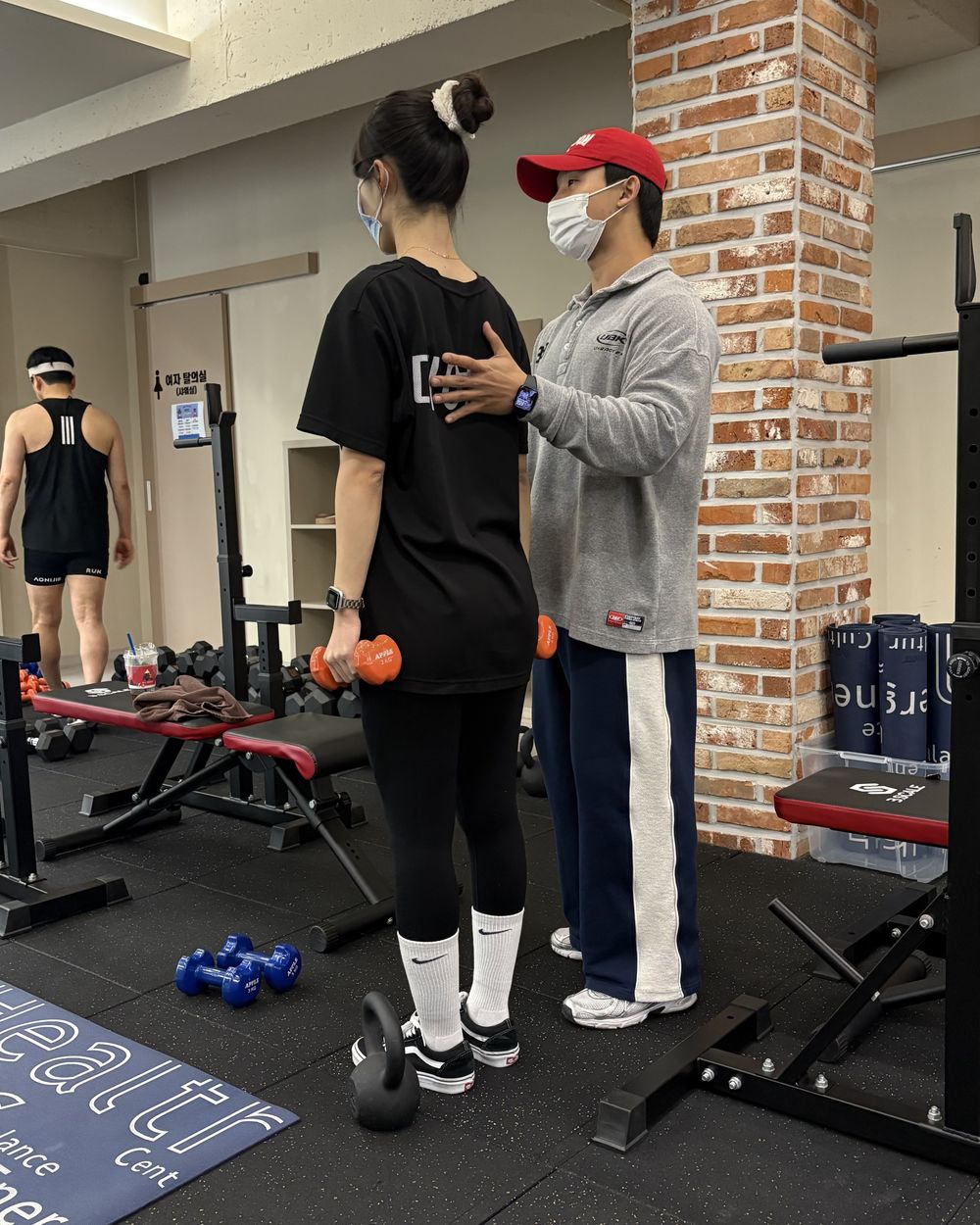 회원의 덤벨 자세를 앞에서 잡아 주는 허인호 대표 트레이너